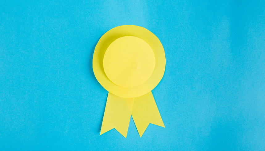 A yellow paper award ribbon with two tails is centered on a bright blue background.