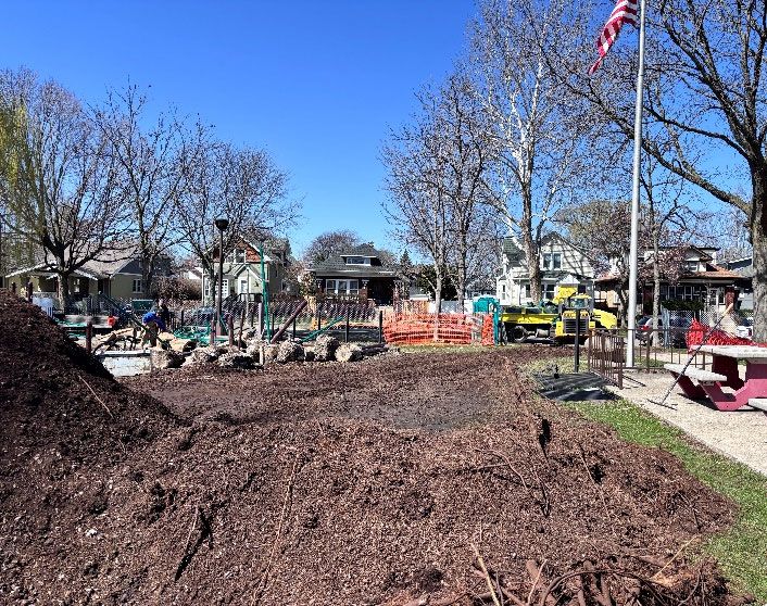 Andersen Park playground under construction with mulch piles, equipment, and machinery.