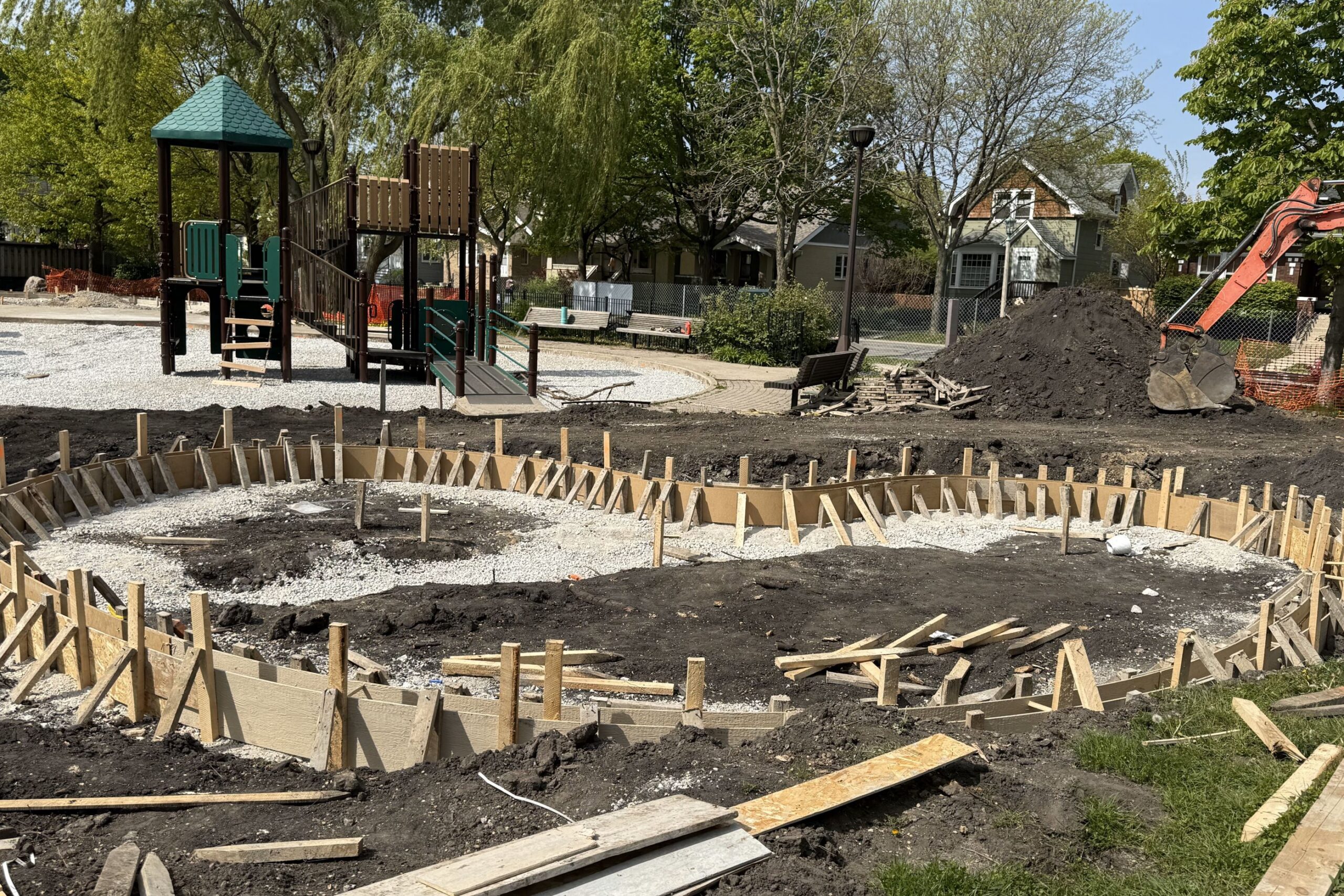 Andersen Park playground under renovation, showing new concrete forms for a circular structure and a playground set in the