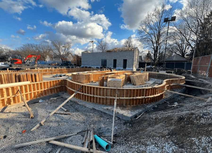 Construction of Rehm Park & Pool shows concrete forms for a pool and a cinder block building under construction.