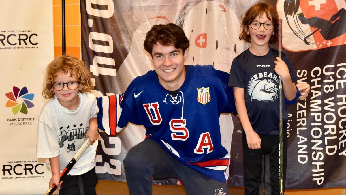 paul fischer poses with young hockey players