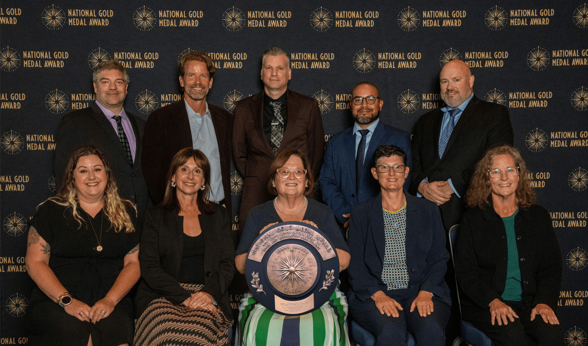 park district board and staff members hold gold medal grand plaque