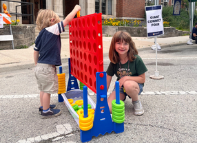 Two children play giant connect four