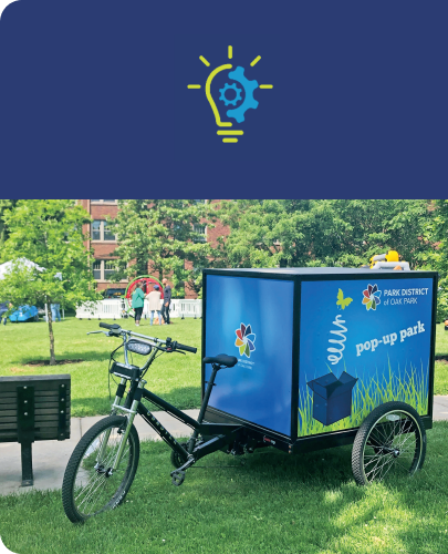 A mobile pop-up park setup on a bicycle in a park