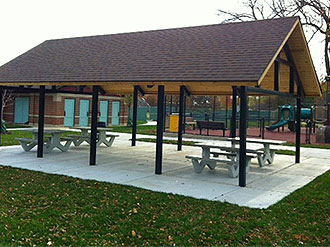 Covered park pavilion with picnic tables and accessible seating area.