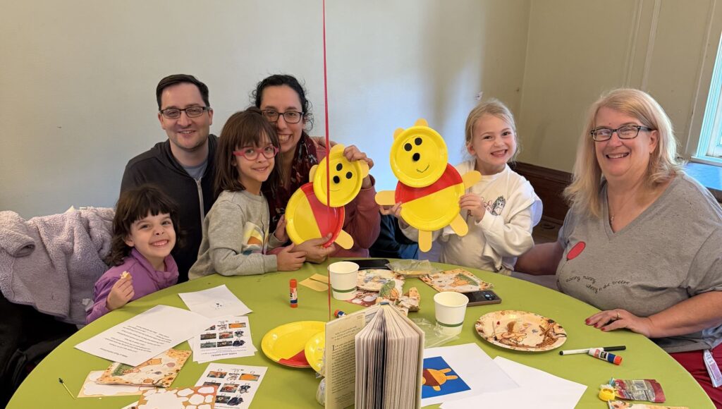 family holds up winnie the pooh crafts