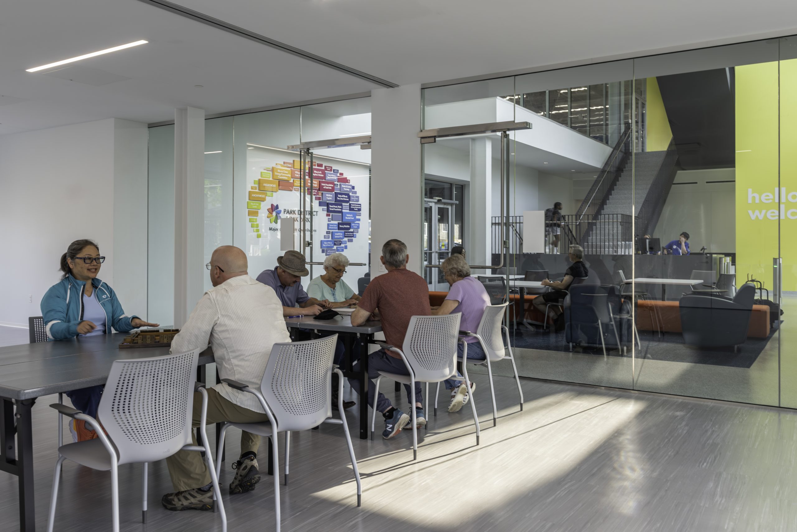 room with windowed doors and several people seated at grey tables