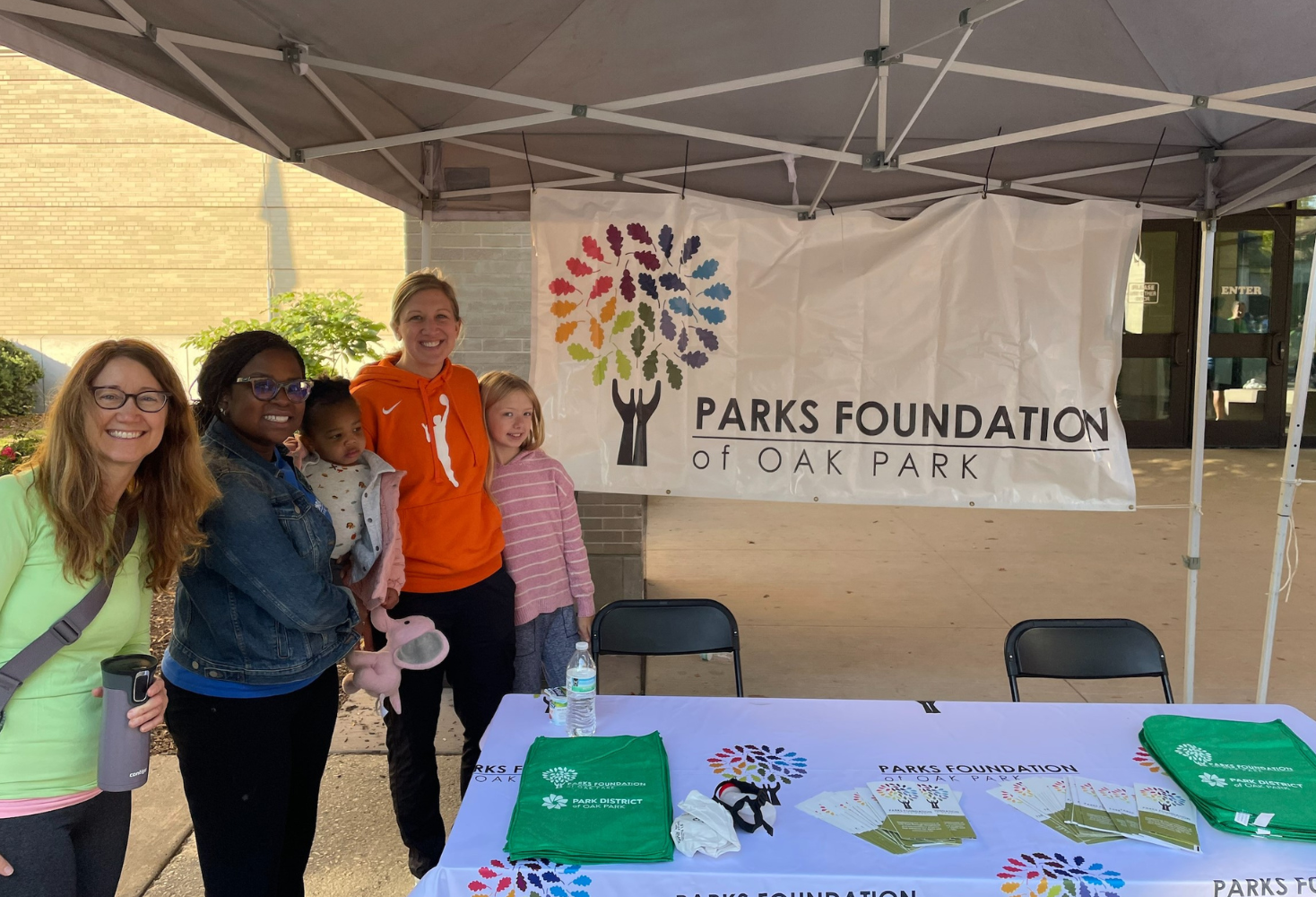 parks foundation members and their families smile in front of a parks foundation banner