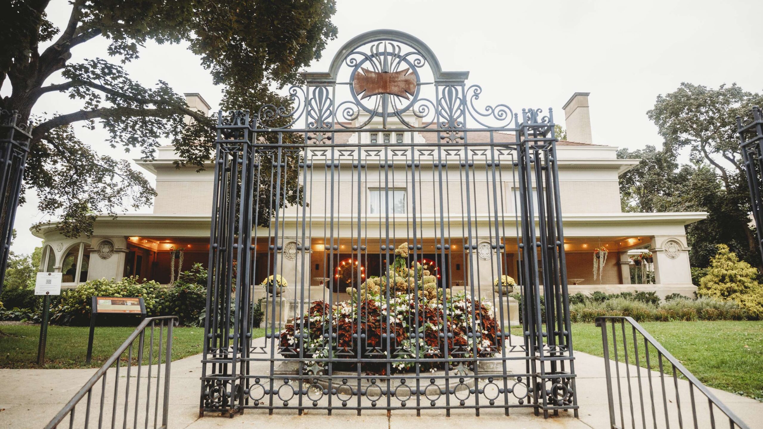 large ornate gate in front of a tan prairie style home