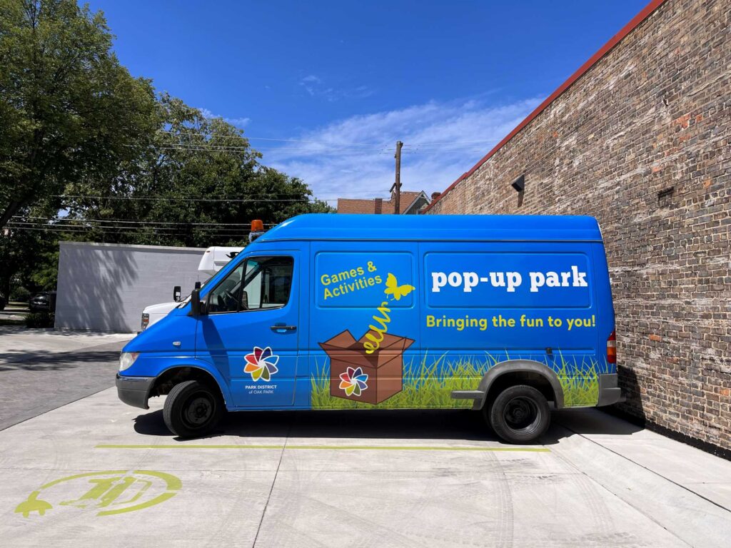 a blue van with pop up park painted on the side