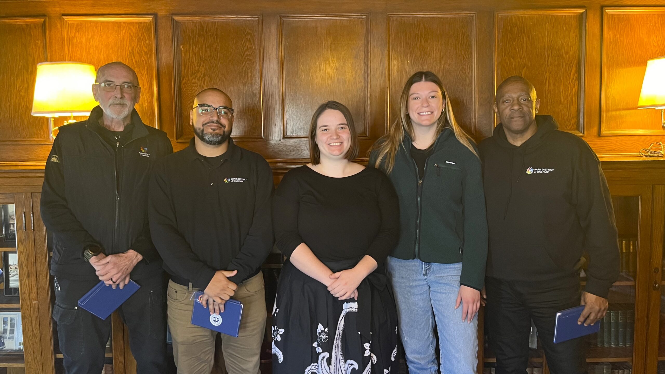 a group of five staff members stand together