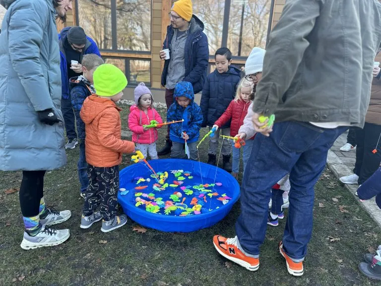 Children fishing for colorful toys in a blue kiddie pool at Winter Fest.